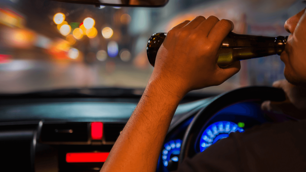 an image showing a man driving and drinking which could end up be a DUI felony situation