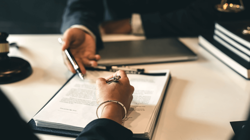 An image of two individuals signing a legally binding payment agreement